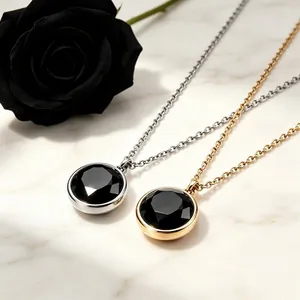 Primer plano de collares redondos de acero titanio con piedras negras en oro y plata