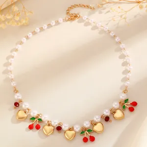 Detailed macro view of an elegant pearl necklace with gold hearts and red cherry charms