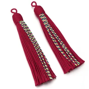 Detailed closeup of red decorative curtain tassels with colorful braided ropes and hanging loops.