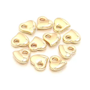 Vue détaillée de perles lisses en forme de cœur doré, parfaites pour bijoux DIY.