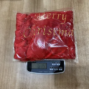 Detailansicht des roten Samt-Weihnachtsgeschenkbeutels mit goldenem Merry Christmas Text.
