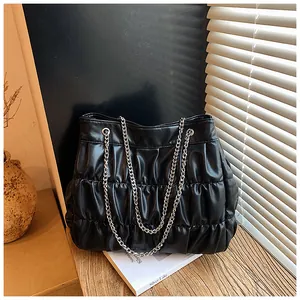 Detailed view of a black pleated leather tote bag with elegant silver chain shoulder straps.