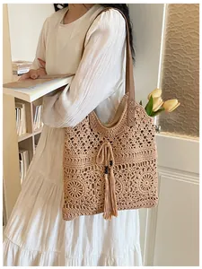 Elegante bolso de hombro de algodón tejido con diseño calado, borla y correa de cuero.