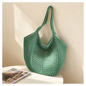 Grüne Häkelstrick Lochmuster Tote Tasche Nahaufnahme Detail zeigt die feine Textur.