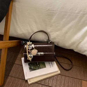 Γυαλιστερή σκούρα καφέ δομημένη μικρή τσάντα χειρός με μεταλλική κλειδαριά και αξεσουάρ.