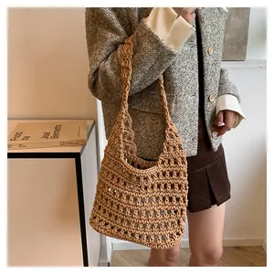 Vista dettagliata di una borsa a spalla in maglia traforata marrone, elegante e casual.