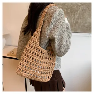 Vista dettagliata di una borsa a tracolla lavorata a maglia beige, versatile e chic.