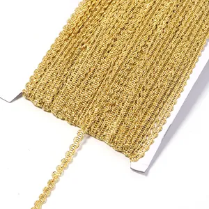Detailed close-up view of metallic gold S-shaped wave lace ribbon trim wound on white card.