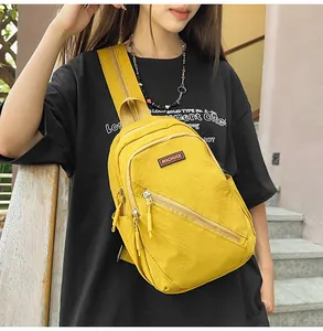 Gros plan sur le sac de poitrine en nylon jaune vif porté avec des fermetures éclair.