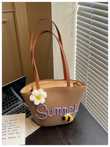 Detail of straw bucket bag with Summer embroidery and crochet flower decoration