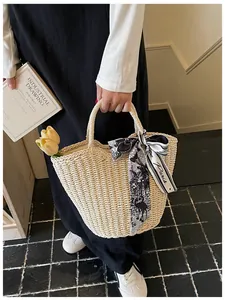 Vista dettagliata della borsa di paglia francese con nastro chic e grande capienza interna.