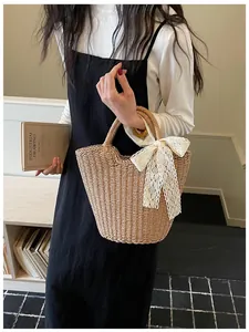 Borsa a mano in paglia stile francese con elegante fiocco in pizzo bianco, ideale per la spiaggia.
