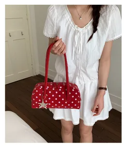 Red polka dot handbag stylish pillow bag with cute star charm and twin top handles detail.