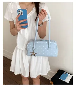 Charming light blue polka dot bowling underarm bag, detailed lifestyle view shot.
