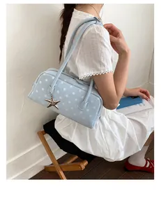 Chic light blue polka dot shoulder bag detail, stylish bowling handbag with star charm.