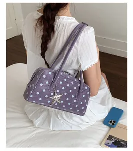 Detail view of a sweet purple polka dot shoulder bag featuring star charm and bowling shape.