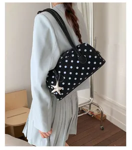 Charming black polka dot shoulder bowling bag detail view, sweet style everyday accessory.