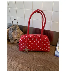Red polka dot bowling shoulder bag detail showing stylish star charm and durable double handles.