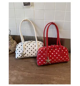Cute polka dot shoulder bag for women, stylish pillow handbag with star charm detail.