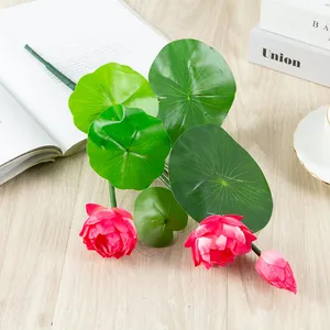 Artificial lotus flowers and green leaves detail, natural home decoration setup.