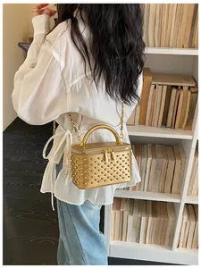 Gold studded vanity crossbody bag with top handle and chain strap for women spring trend.