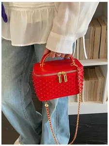 Red pearl studded box handbag detail shot, showing the exquisite gold chain and double zippers.