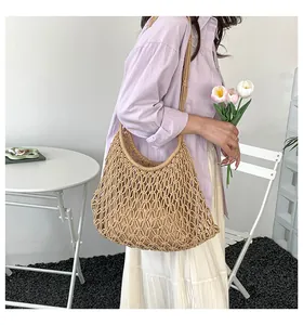 Beige woven hollow-out tote bag shown on model in a minimalist lifestyle setting