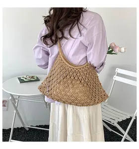 Back view of a woman wearing a lavender shirt and a hollow woven hobo shoulder bag