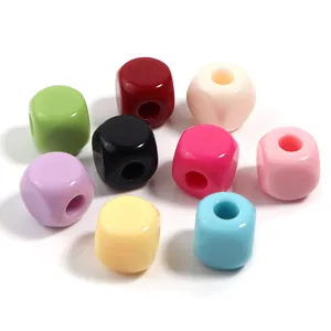 Primer plano de cuentas cubicas de acrilico de colores con grandes agujeros para pulseras.