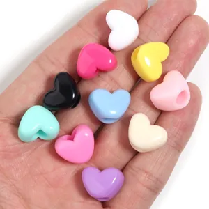 Dettaglio di perline a cuore in acrilico colorato, ideali per braccialetti e gioielli fai da te.