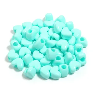 Primo piano di perle sfuse a cuore in acrilico azzurro per braccialetti fai da te artigianato.