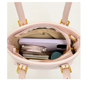 Detailed interior view of pink bucket bag showing storage capacity for phone and cosmetics