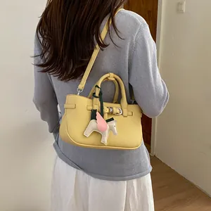 Yellow leather shoulder bag retro style top handle bag with cute winged horse charm.