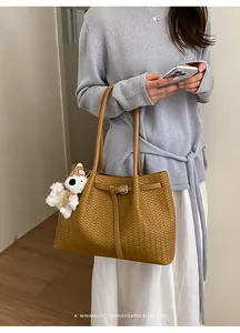 Schicke geflochtene Tragetasche im minimalistischen Retro-Look mit einem Modell.