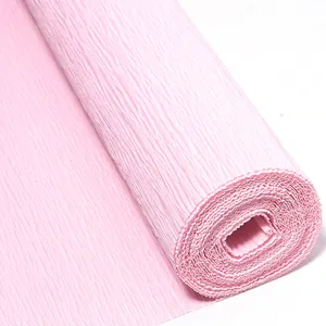 Primer plano de un rollo de papel crepé rosa claro, ideal para manualidades florales hechas a mano.
