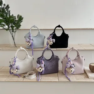 Detailaufnahme von modischen Eimer taschen in mehreren Farben mit Bären Anhängern.
