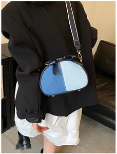 Detailansicht der Damen Jeans Patchwork Umhängetasche mit Schleife und breitem Gurt.