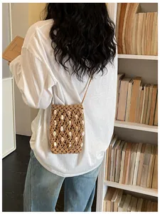 Detailed view of a handmade beaded woven crossbody phone bag for beach vacations