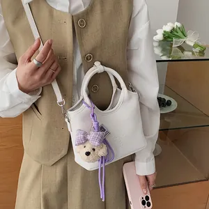 Stilvolle weiße Ledertasche mit Bärenanhänger, ideal für den Alltag und schicke Outfits.