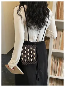 Bohemian dark brown woven rope crossbody bag detail, natural shell beads and shoulder strap.