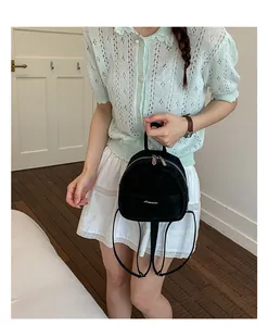 Small black backpack minimalist casual school bag for women daily wear detail view.