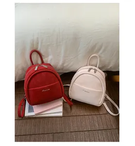 Detail view of mini women backpack in red and pink, featuring front pocket and casual style.