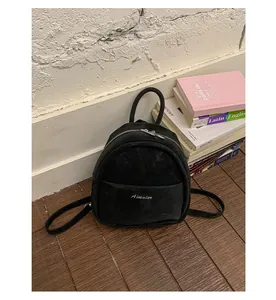 Chic black mini backpack detailed view showcasing soft suede texture, front pocket and zipper.