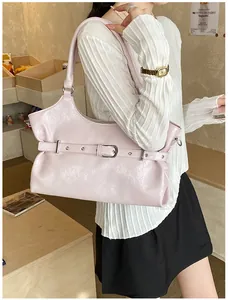Gedetailleerde weergave van een stijlvolle roze tote tas met een decoratieve riemgesp sluiting.
