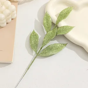 Glitter green artificial leaves branch close-up, perfect for Christmas tree decoration.