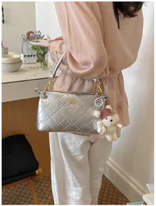 Silver metallic quilted underarm bag with cute bear keychain for women trendy commuting.