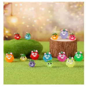 Vue détaillée de figurines d'esprits de fruits en résine lumineuse dans un décor de jardin.