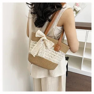 Straw woven shoulder bag with delicate lace bow detail, perfect for summer beach and vacation.