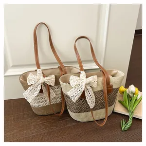 Straw woven beach tote bag with elegant lace bow and PU leather handles for summer vacation.