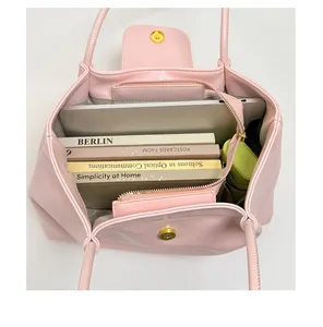 Spacious interior of a pink pleated tote bag with laptop and books for college
